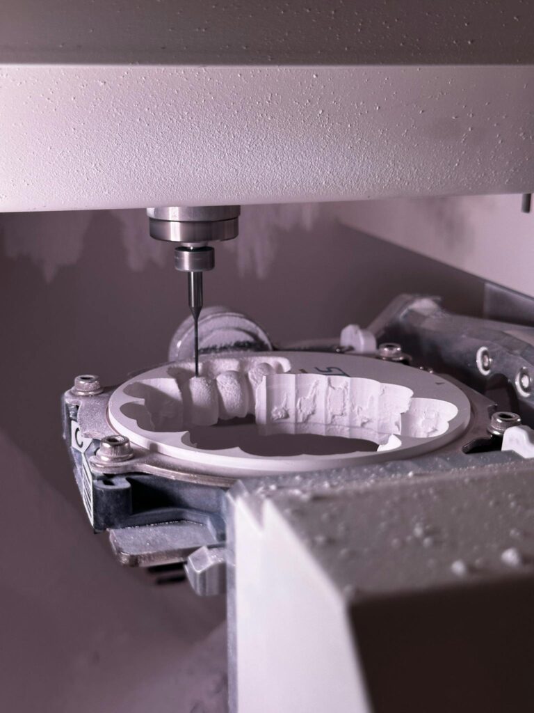 Detailed view of CNC grinding machine shaping ceramic material with precision tool.